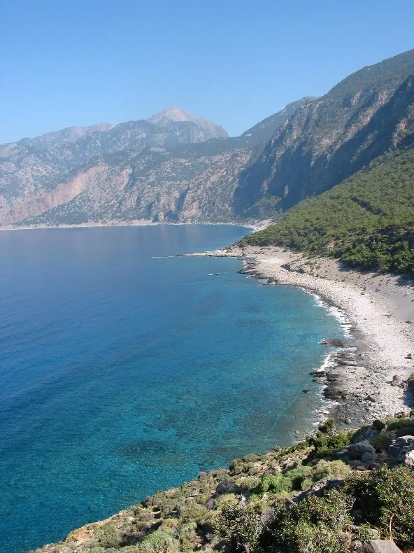 Mountainous Cretan coastline beside clear blue water