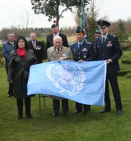 Guests at the unveiling holding the United Nations flag