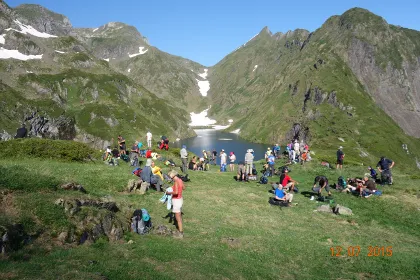 Chemin de la Liberte walkers gathered beside a mountain lake