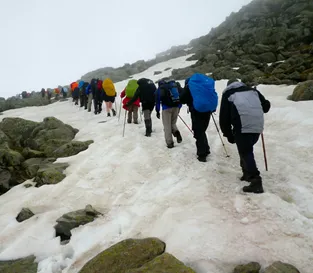 Walkers crossing snow on the Chemin route