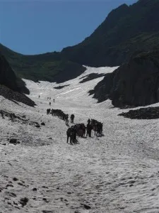Walkers crossing snow on the high Pyrenees trail